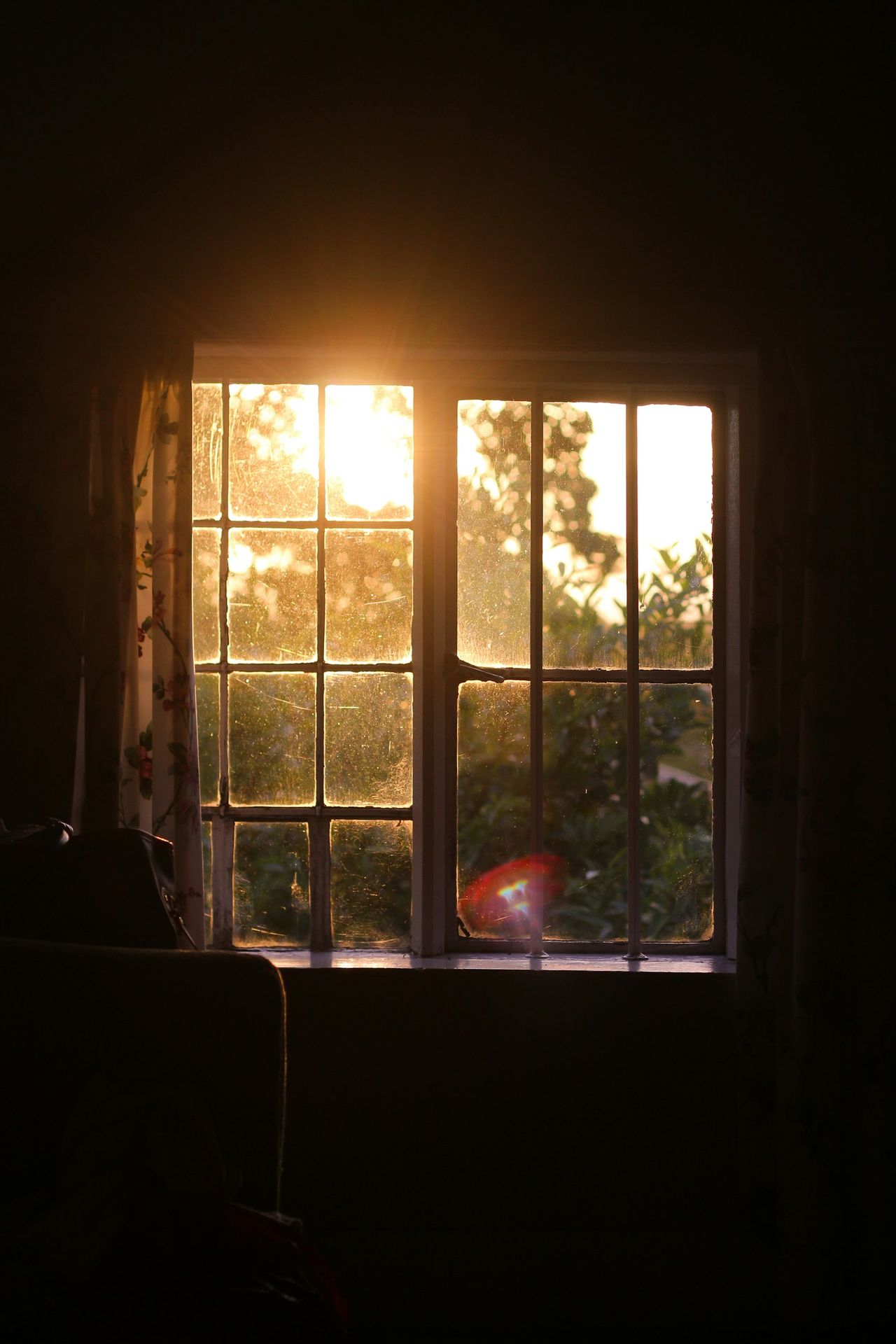 The sun is shining through a window in a dark room